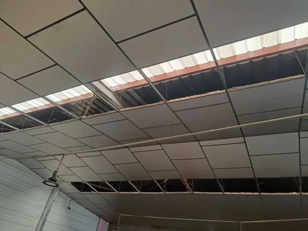 Interior de la nave industrial con parte del falso techo abierto y la estructura metálica de la cubierta a la vista